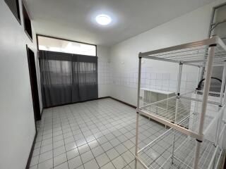 Spacious utility room with tiled flooring and shelving