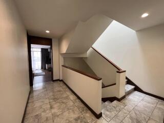 Interior staircase and hallway with marble flooring