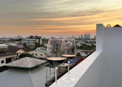 Balcony with a scenic view and two glasses of wine at sunset