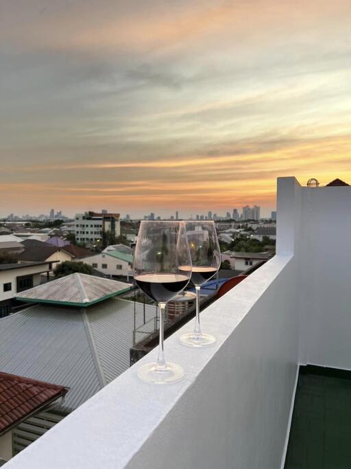 Balcony with a scenic view and two glasses of wine at sunset