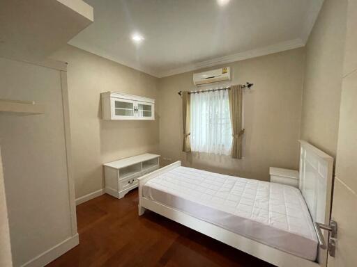 Cozy bedroom with double bed, wooden floor, and natural light