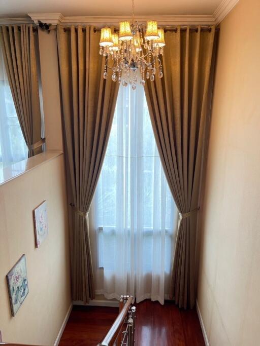 Well-lit stairwell with chandelier and window