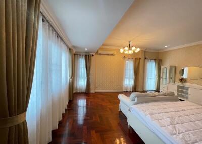 Spacious bedroom with wooden flooring and large windows