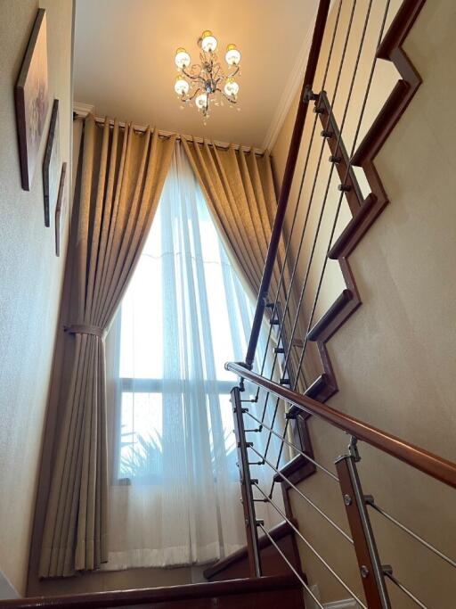 Modern staircase with chandelier and large window