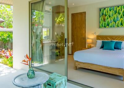 Bright bedroom with glass doors leading to a garden