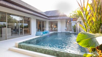 Modern outdoor pool area with lounge chairs and a view of the house