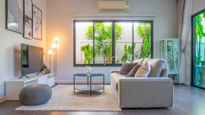 Modern living room with large window and greenery