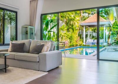 Spacious living room with view of outdoor pool and greenery