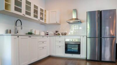 Modern kitchen with white cabinets and stainless steel appliances