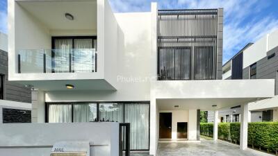 Modern two-story house with large windows and balcony