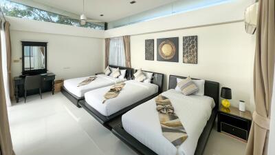 Spacious modern bedroom with three single beds and stylish decor