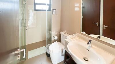 Modern bathroom with glass shower, sink, and toilet