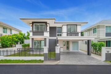 Modern two-story house with driveway and greenery