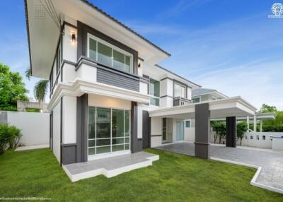 Modern two-story house exterior with lawn and covered driveway