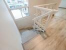 Staircase with wooden handrails and a view of a window.