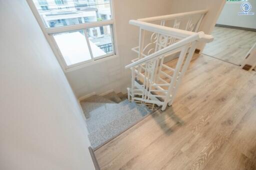 Staircase with wooden handrails and a view of a window.