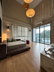 Spacious living room with large windows, wooden flooring, and modern decor