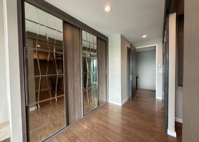 Spacious hallway with wooden flooring and mirrored closets