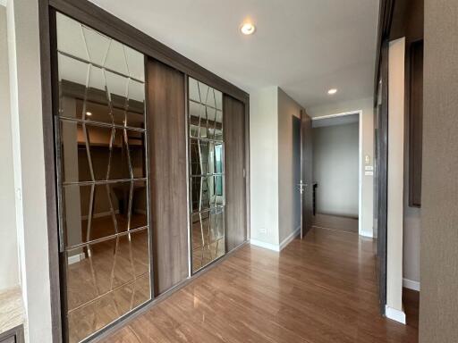 Spacious hallway with wooden flooring and mirrored closets
