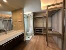 Modern bathroom with large mirror, double sink, shower, and walk-in closet