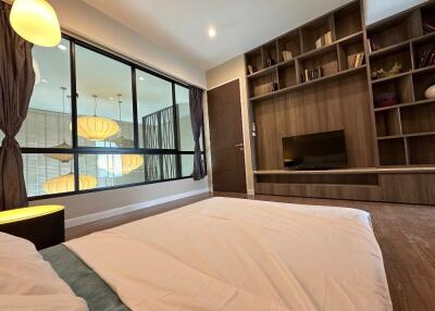 Modern bedroom with large window and built-in shelving