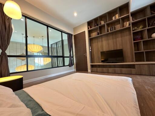 Modern bedroom with large window and built-in shelving