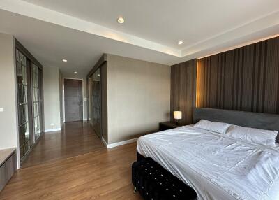 Spacious and modern bedroom with wooden flooring and large windows