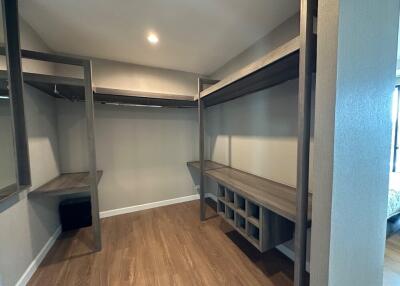 Spacious walk-in closet with wooden shelving and hanging space