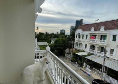 Balcony with a view of neighborhood and a dog