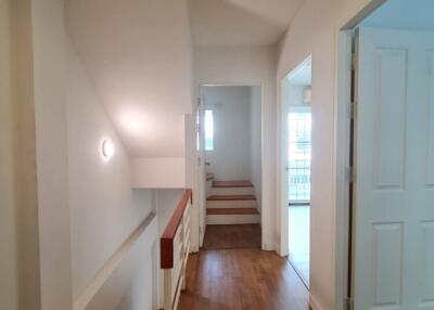 Bright hallway with wooden flooring and staircase