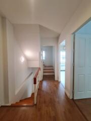 Bright hallway with wooden flooring and staircase