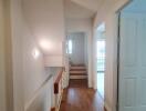 Bright hallway with wooden flooring and staircase