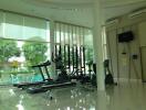 Fitness center with exercise equipment and large windows