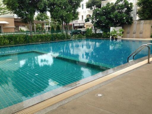 Swimming pool area with tiling and surrounding greenery