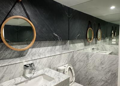 Modern bathroom with marble walls and round mirrors