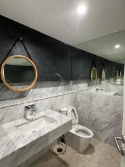 Modern bathroom with marble walls and round mirrors