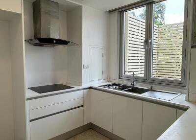 Modern kitchen with white cabinets and a large window