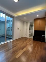 Spacious living room with wooden flooring, recessed lighting, sliding glass doors, and built-in cabinetry.