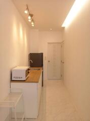 Narrow kitchen with modern lighting fixtures and wooden countertop