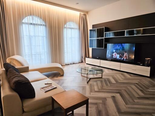 Modern living room with large windows, TV, and contemporary furniture