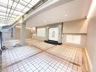 Well-lit carport with tiled flooring and glass doors