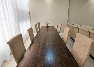 Elegant dining area featuring a long wooden table with six beige chairs