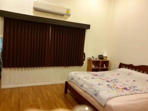 Comfortable bedroom with air conditioning and wooden flooring