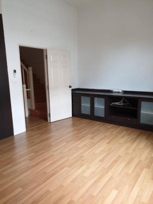 Spacious living room with wooden flooring and built-in shelves