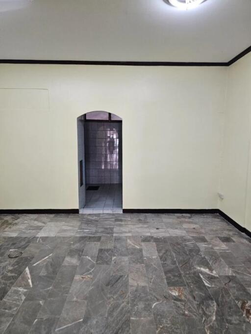 Living area with tiled floor and doorway leading to another room