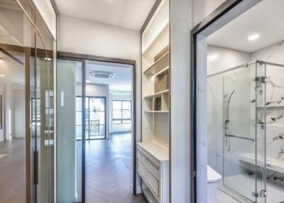 Hallway with a view into an adjoining living area and bathroom