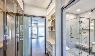 Hallway with a view into an adjoining living area and bathroom