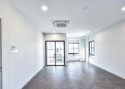 Spacious living room with herringbone flooring and large windows