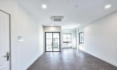 Spacious living room with herringbone flooring and large windows