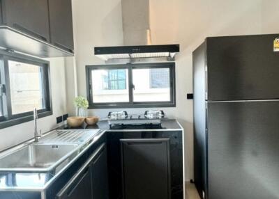 Modern kitchen with black cabinets and stainless steel appliances